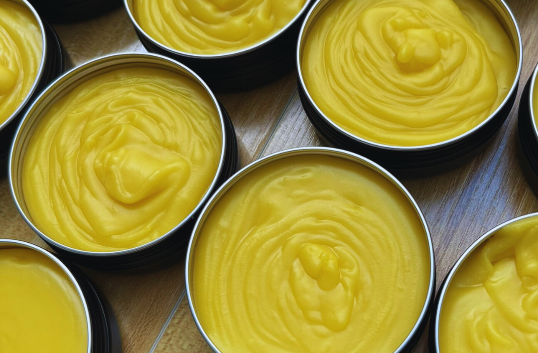 Golden herbal balms in tin jars